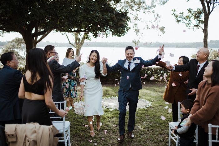 Bride and groom celebrating with hands in air after getting married_Sydney Celebrant Andrea Calodolce