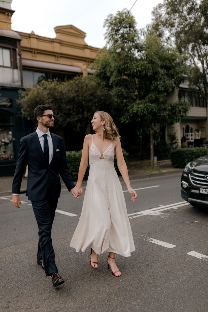 Bride and groom crossing road holding hands
