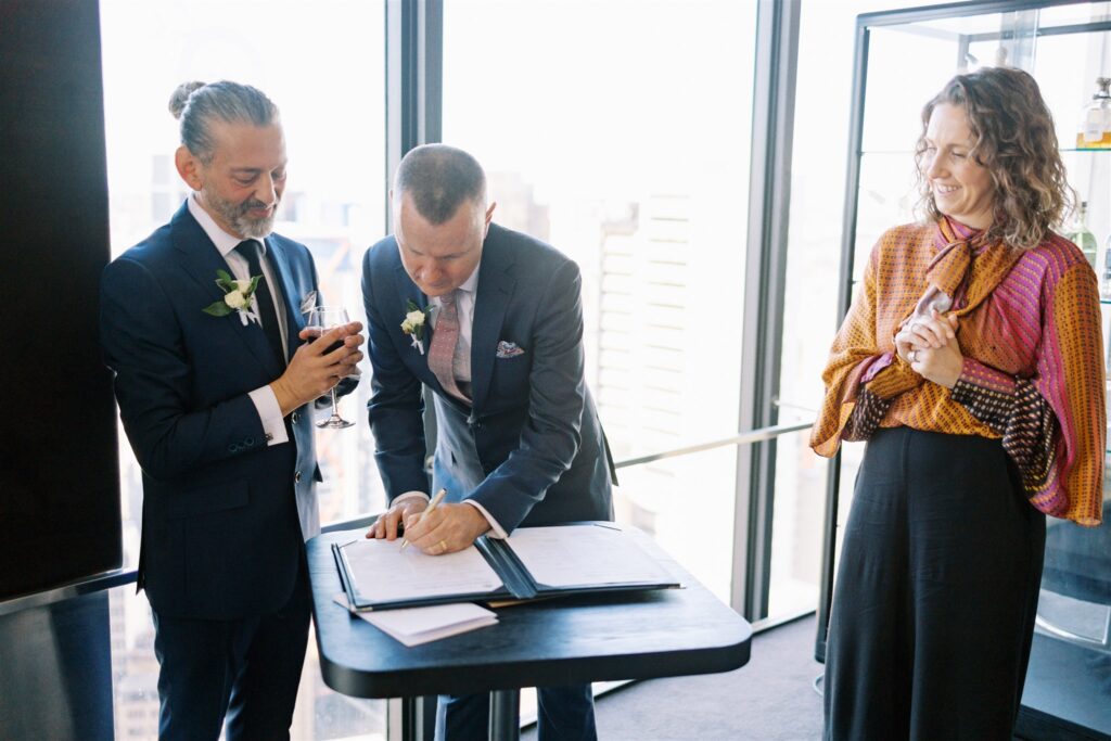 John and Jeff signing marriage paperwork with their marriage celebrant Andrea Calodolce at O Bar and Dining in Sydney