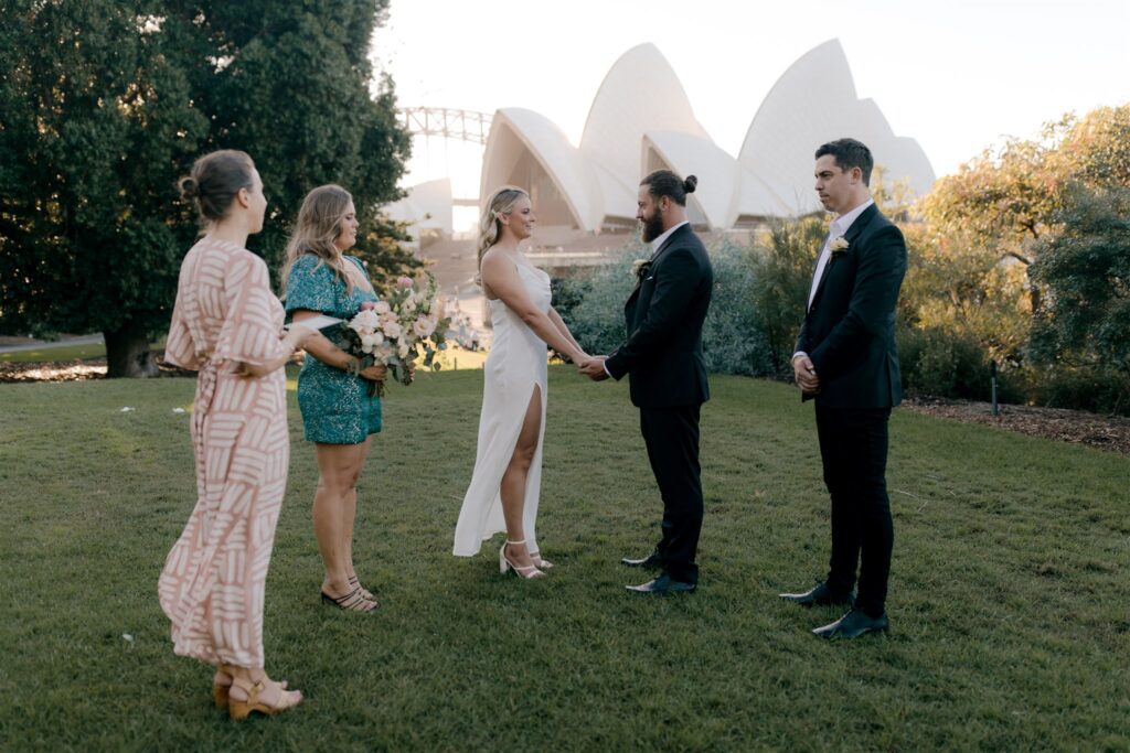 Bride and groom with two witnesses and celebrant Andrea Calodolce getting married in Royal Botanic Gardens with view of the Sydney Opera House